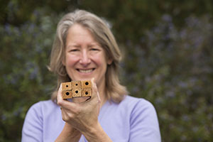 Professor of Biology Gretchen LeBuhn holds examples of bee nesting sites